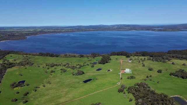 Beautiful farmland and the WIlson Inlet with the Nullaki in the background. Aerial footage 4k drone, blue sunny day with green grass and blue water. Denamrk Western Australia
