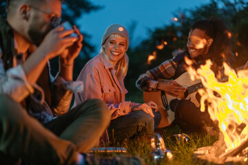 Naklejka premium Cute girl enjoying camping at night with her friends