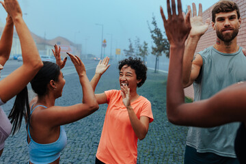 Fitness enthusiasts celebrating success outdoors after group workout