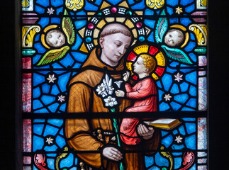 Stained glass (19th century) of Saint Anthony of Padua holding baby Jesus Christ in his arms.