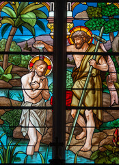 Stained glass (1920) of Baptism of Jesus by John the Baptist in the Jordan river.