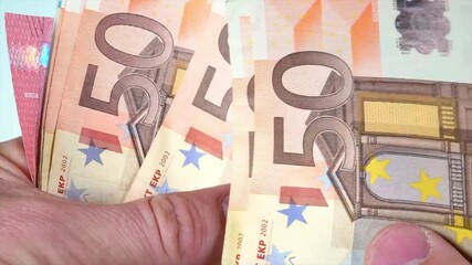 male hands counting his income, close up video. man counting money, 50 euro bills, finance concept. video of an unrecognizable person counting 50 euro bills. counting a wad of 50 euro bills.