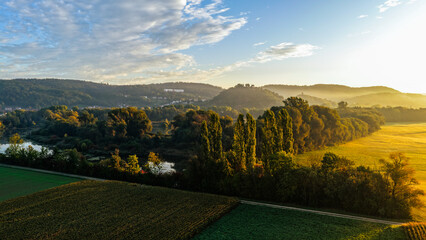 Morning Light Over Lush Forest, Fields and Hillside Village