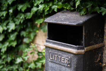 Litter bin in green park setting, useful for awareness posters, digital campaigns