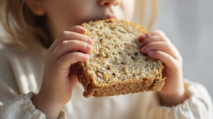 Close-up of child eating multigrain bread for breakfast