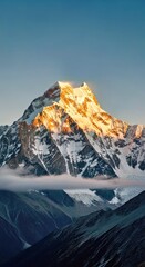 Snow-Capped Mountain Peak at Dawn with Golden Hour Sunlight
