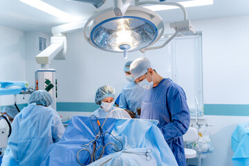 Surgeons perform surgery in a modern operating room. Medical professionals work together during a surgical procedure in a well-equipped operating room.