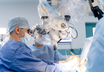 Surgeons in a high-tech operating room. Surgeons are engaged in a detailed operation using advanced surgical tools in a clean, bright hospital environment.