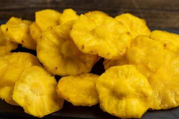 dried ripe bright yellow pineapple fruits on a slate board, cut into rings and dried yellow clean slices of ripe pineapple for long-term storage and used as a sweet