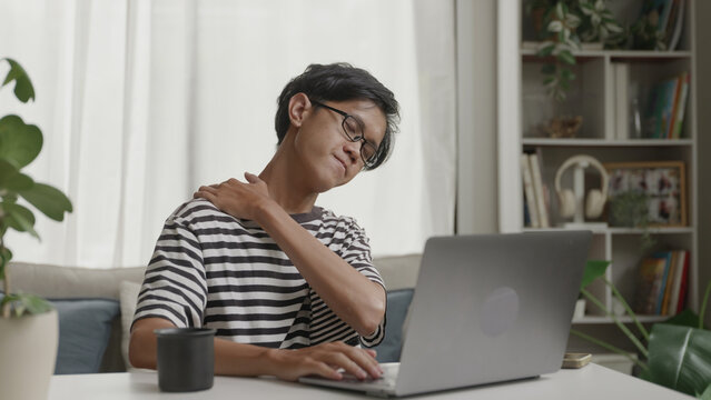 Asian man stretching muscles after working at home for relaxation.