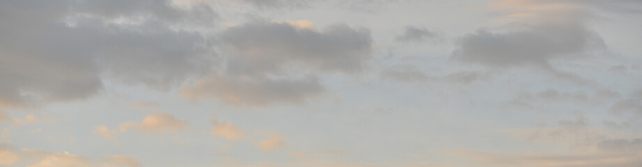 Panorama de nuages cumulus foncé dans un ciel bleu pastel au lever du soleil
