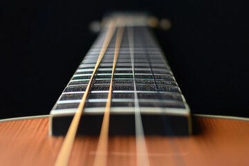 Weird angles and unconventional perspectives create dramatic view of guitar strings and fretboard with artistic focus and depth