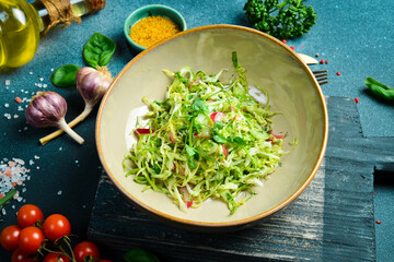 Healthy food. Fresh cabbage salad, radishes with olive oil. On a plate. Restaurant serving. Close up. On a dark stone background.