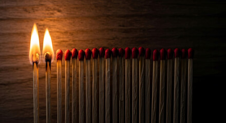 Two Burning Matches Leading a Row of Unlit Matches on Wooden Background fire flame