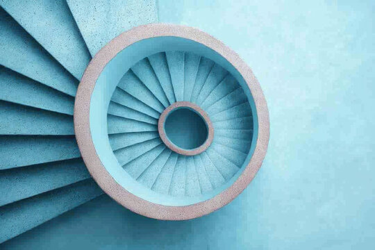 Weird spiral staircase captured from above shows unconventional angles and unique perspectives in modern architecture with calming blue tone