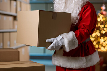 Santa Claus holding a box at the distribution warehouse