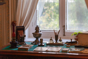 A writing desk with antique household items arranged on it