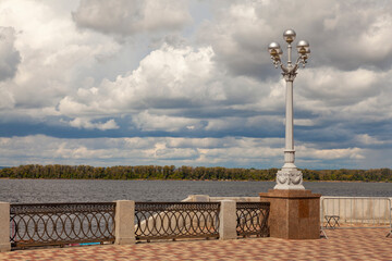 A picturesque street lamp stands on the river embankment