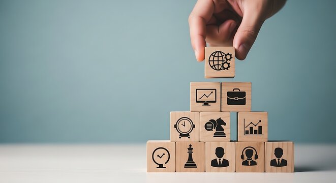 Hand stacking wooden blocks with business icons in pyramid strategy success