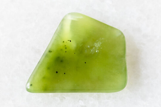 polished light green nephrite mineral on white