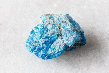 sample of unworked apatite rock on white marble