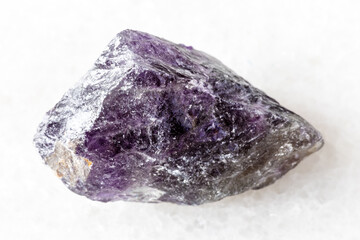 sample of raw amethyst mineral on white marble