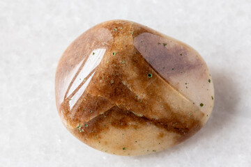 sample of tumbled brown quartzite rock on white