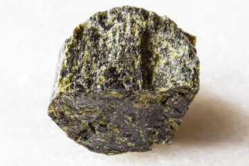 sample of rough diopside mineral on white marble
