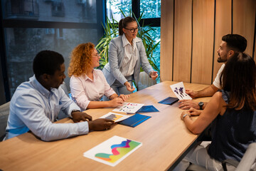 Diverse business team discussing strategy and analyzing creative marketing data