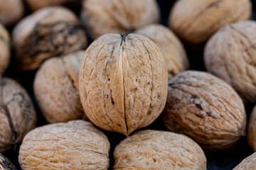 A pile of walnuts with the one in the middle being the largest