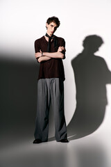 Stylish young man showcasing contemporary fashion in a minimalist setting with dramatic lighting
