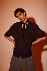 Stylish young man showcases modern fashion in a creative studio setting