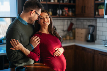 Man in love hugs his pregnant wife, they are waiting together for the baby's arrival. Love, family
