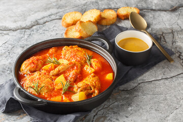 Chicken Bouillabaisse cooked in a delicious rich and fragrant broth closeup in the saucepan on the table. Horizontal
