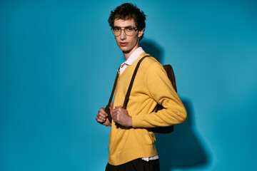 Stylish young man showcases modern fashion against a vibrant blue background