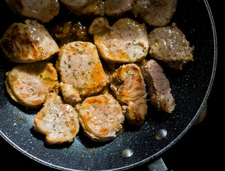 Close Up of Golden Brown Fried Pork Fillets Loins in a Pan with Herbs