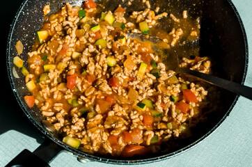 Bolognese sauce with Minced Meat, Tomato, Onions, Red Pepper, Courgettes, Olive Oil in a Cooking Pan