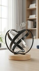 A modern, artistic  sculpture, featuring a polished silver  shape with intersecting, flowing black bands, rests on a light beige wooden base, creating a sophisticated and contemporary decorative...