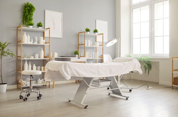 Clean, spacious cosmetology treatment room with professional treatment chair, modern equipment, and...