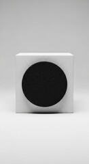 A minimalist white cube with a black circle on its front surface, set against a plain white background.