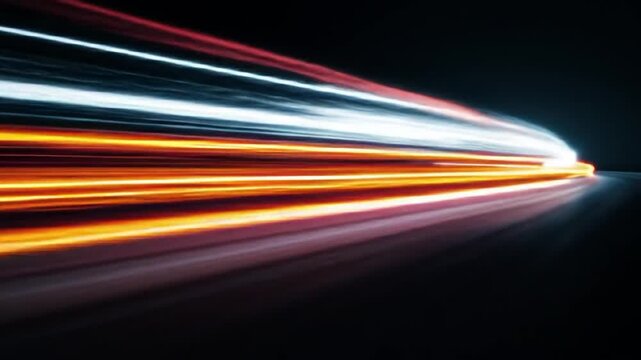 Abstract long exposure of blurred orange/white light trails on black