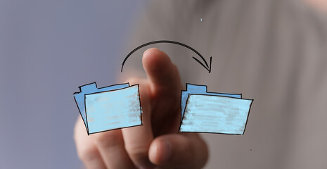 Stock photo of a hand interacting with digital folders, symbolizing file transfer, data exchange,...