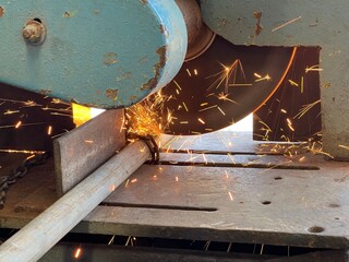 Industrial metal cutting process with circular saw machine creating bright sparks – perfect for illustrating manufacturing, fabrication, and construction industry operations.