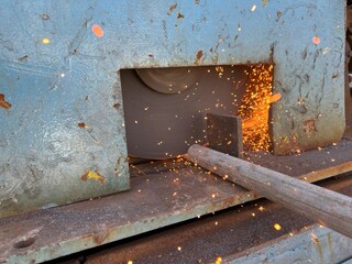 Industrial circular saw cutting metal pipe with bright flying sparks – ideal for representing heavy machinery, manufacturing processes, and fabrication safety themes.