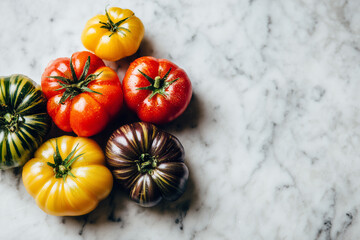 Fresh organic heirloom tomatoes in vibrant colors on marble