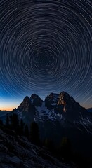 A dramatic mountain vista under a night sky displaying a mesmerizing pattern of star trails.