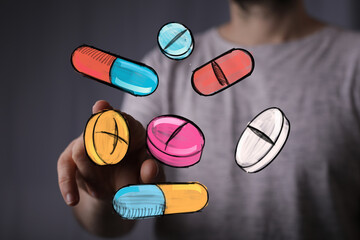 Image of hand interacting with colorful pills and capsules.  Perfect for healthcare, medicine, and pharmacy concepts.