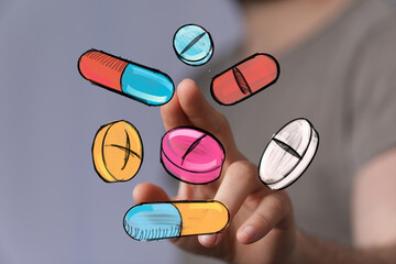 Close-up of hand interacting with colorful illustrated pills and capsules.  Perfect for healthcare, medicine, pharmacy.