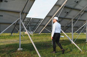 Engineer inspecting solar panels in renewable energy field
