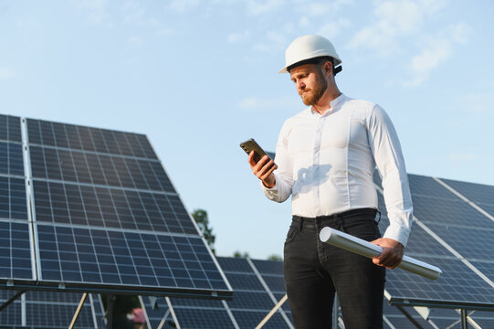 Engineer checking solar panel performance on phone